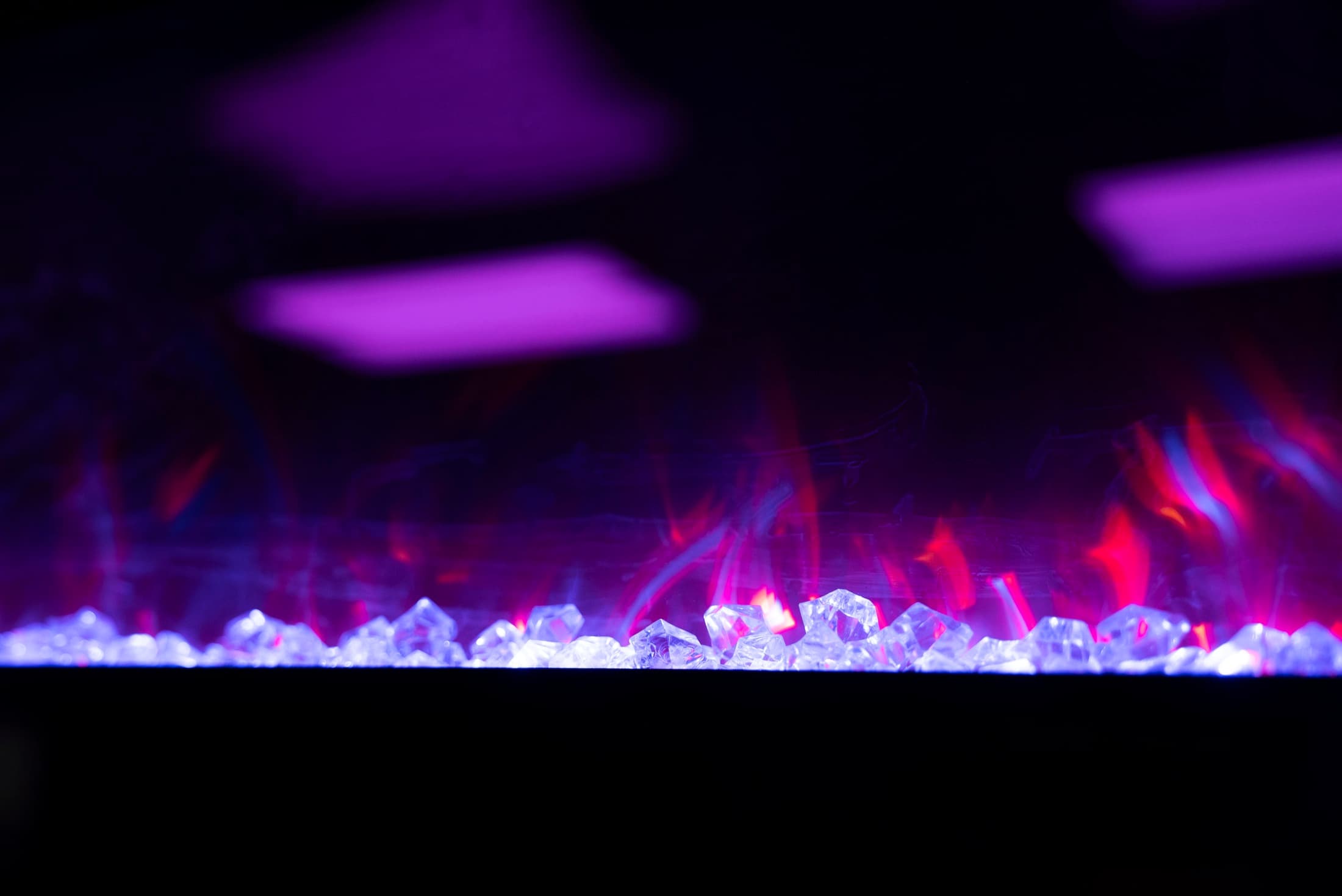 Close-up of the fireplace at Lush Event Space — crystal bed lit violet and pink