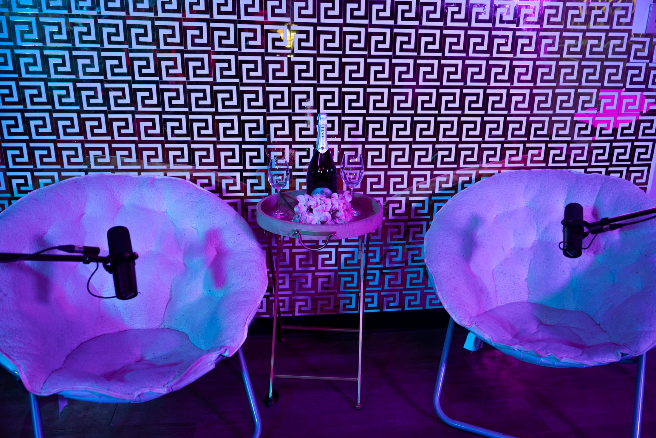 The Gold Room set at Lush Event Space — two plush chairs face to face against a gold Versace-pattern wall with champagne service